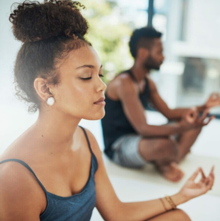 Man and woman doing meditation in a sunny room