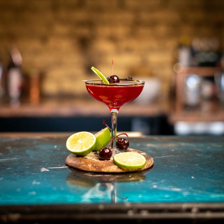 Profile photo of Red Admiral cocktail on coaster with lime slices