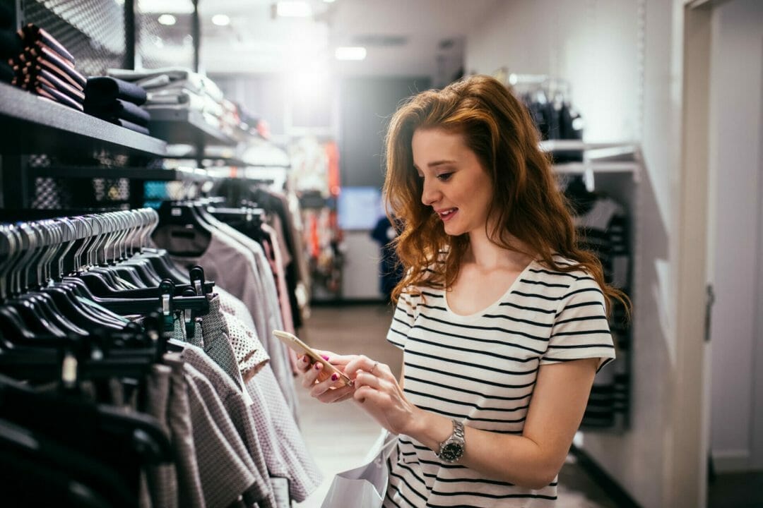 Female consumer browses social media while shopping.